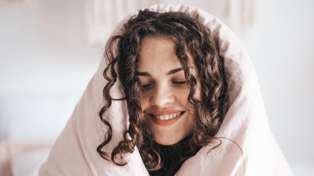 The Transformative Power of Self-Care - Woman with blanket over her head and relaxed