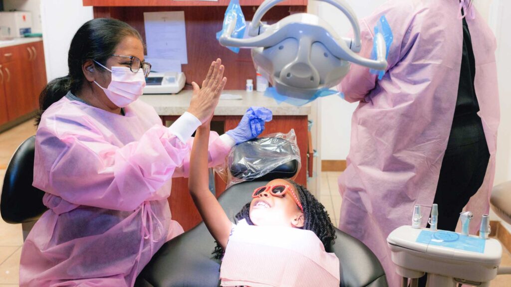 Dr. Yashashri Urankar, dentist with pediatric patient high-five