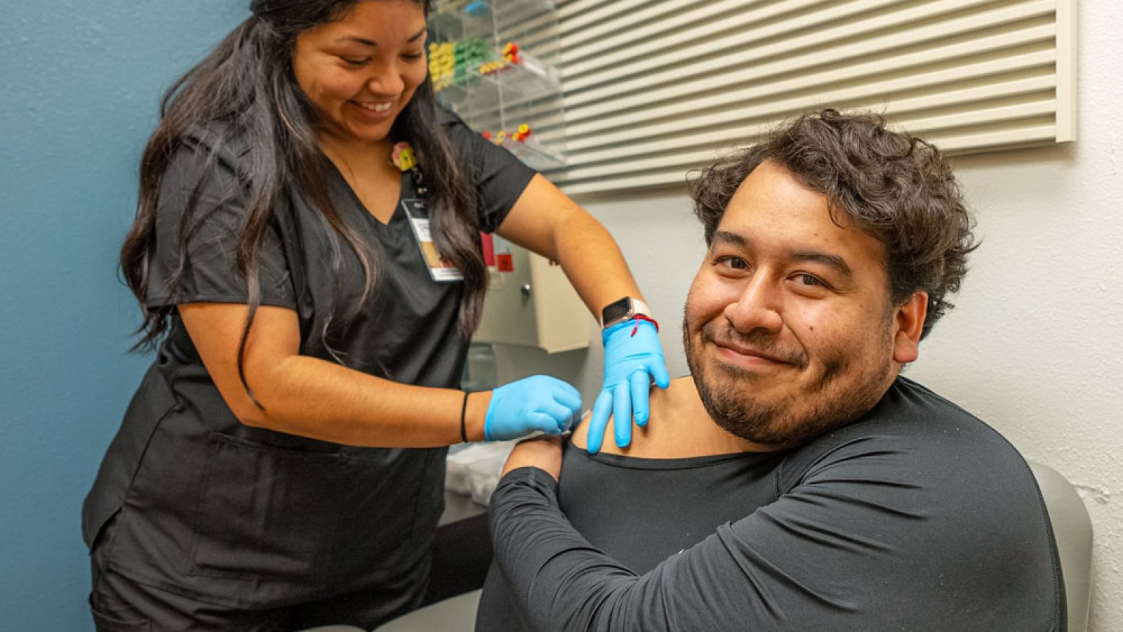 COVID 19 Services_Male patients receives a COVID-19 vaccine from a female lab technician.