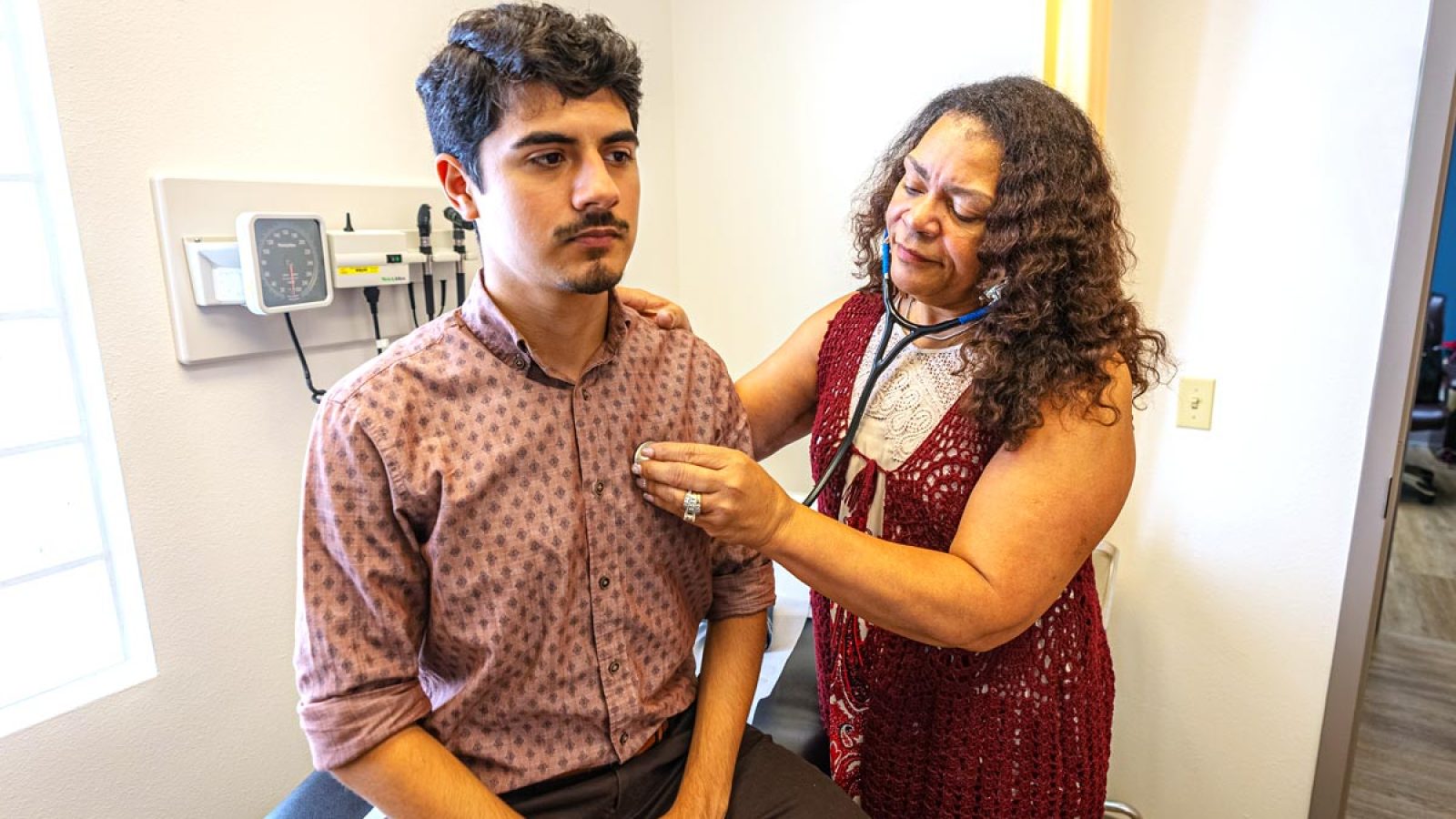 Male patient is receiving a heart health check during an appointment with a female nurse.