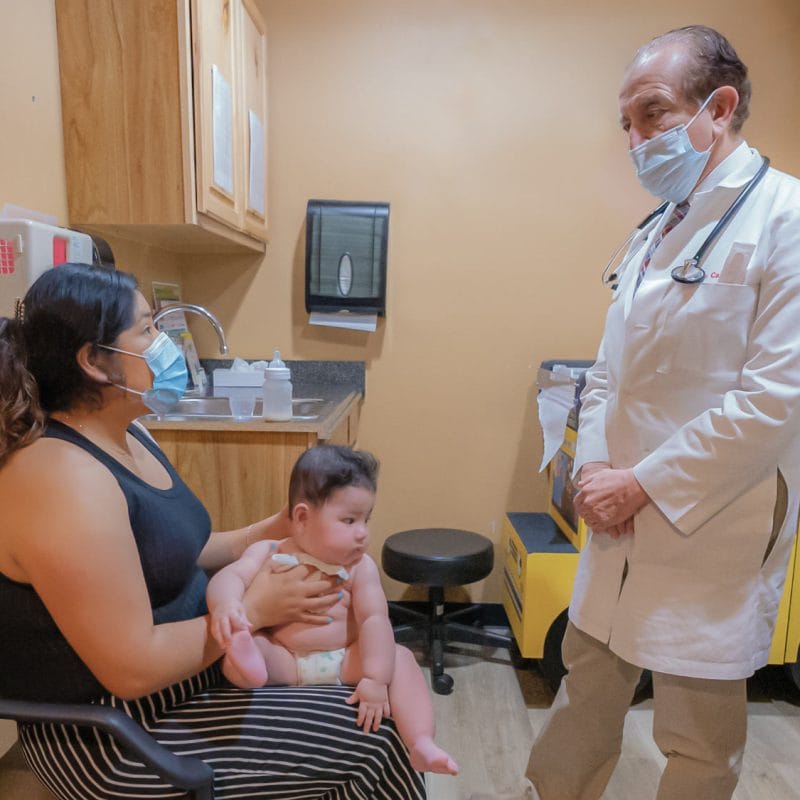mother and baby visit with a male pediatrician for an annual well check visit pediatrics pediatria at Community Health Centers of South Central Texas serving the community
